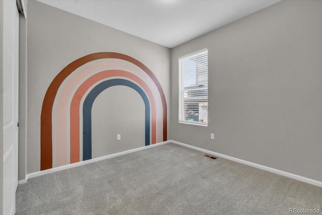 12862 Crane River Dr, Longmont, CO 80504 - carpeted empty room featuring baseboards and arched walkways