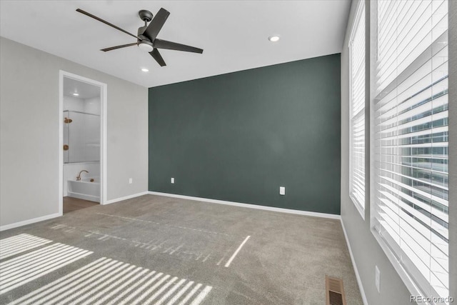 12862 Crane River Dr, Longmont, CO 80504 - unfurnished bedroom featuring carpet flooring, multiple windows, recessed lighting, connected bathroom, and a ceiling fan