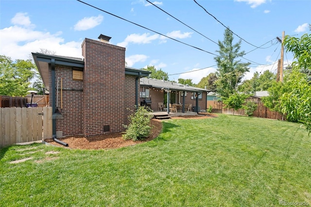 5455 E Iowa Ave, Denver, CO 80222 - back of property featuring a chimney, a patio area, and brick siding