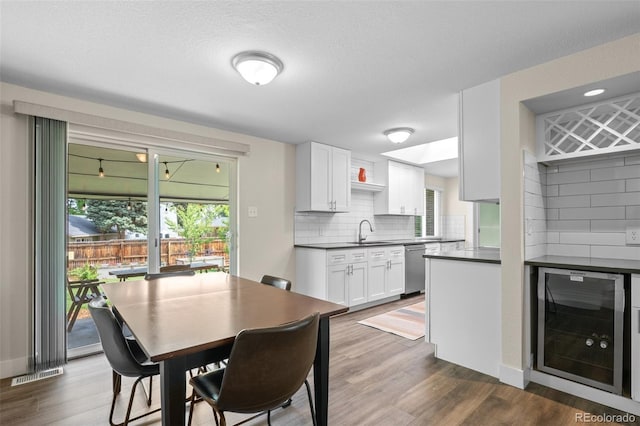 5455 E Iowa Ave, Denver, CO 80222 - dining space with wine cooler, dark wood finished floors, and a textured ceiling