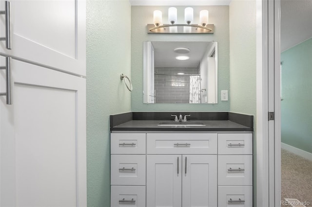 5455 E Iowa Ave, Denver, CO 80222 - bathroom featuring vanity, baseboards, a shower with shower curtain, and a textured wall