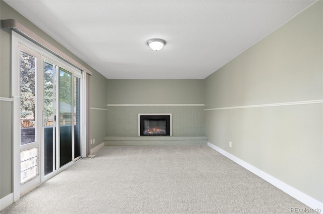 5455 E Iowa Ave, Denver, CO 80222 - unfurnished living room featuring carpet floors, a brick fireplace, and baseboards