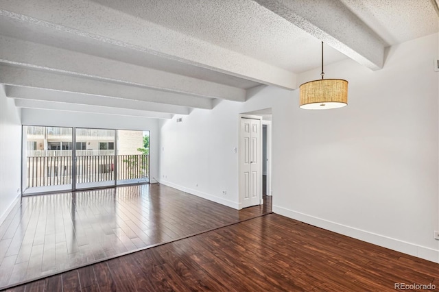 empty room with beam ceiling, a textured ceiling, and dark wood-type flooring