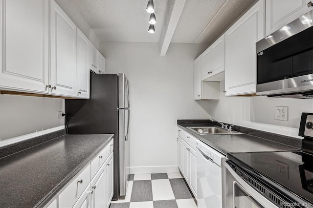 kitchen with white cabinets, sink, rail lighting, and stainless steel appliances