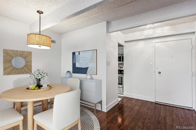 dining room featuring dark hardwood / wood-style flooring and a textured ceiling