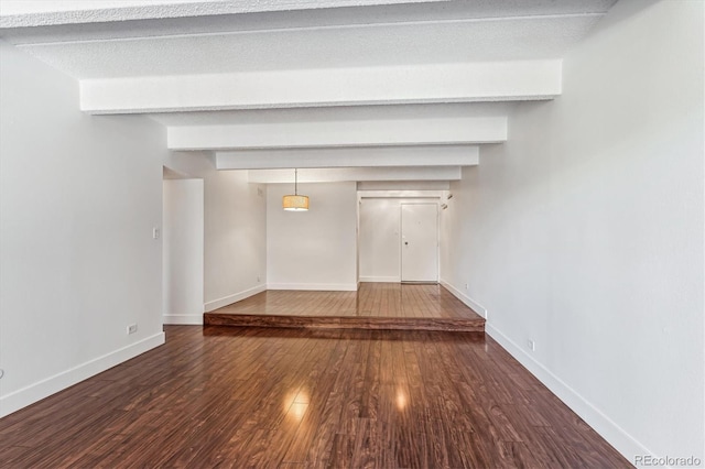 unfurnished living room featuring beamed ceiling, dark hardwood / wood-style floors, and a textured ceiling