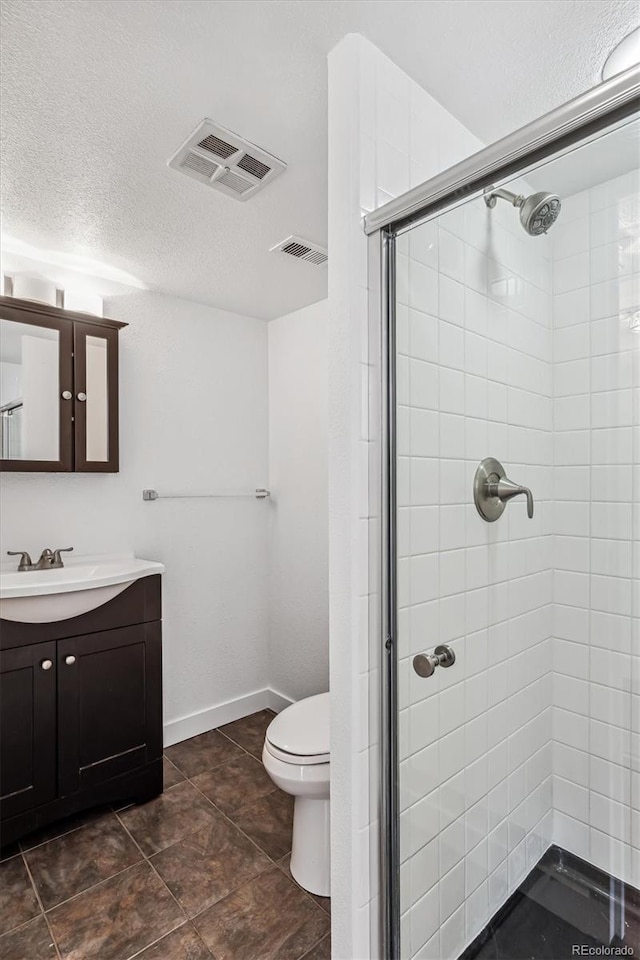 bathroom featuring walk in shower, vanity, a textured ceiling, and toilet