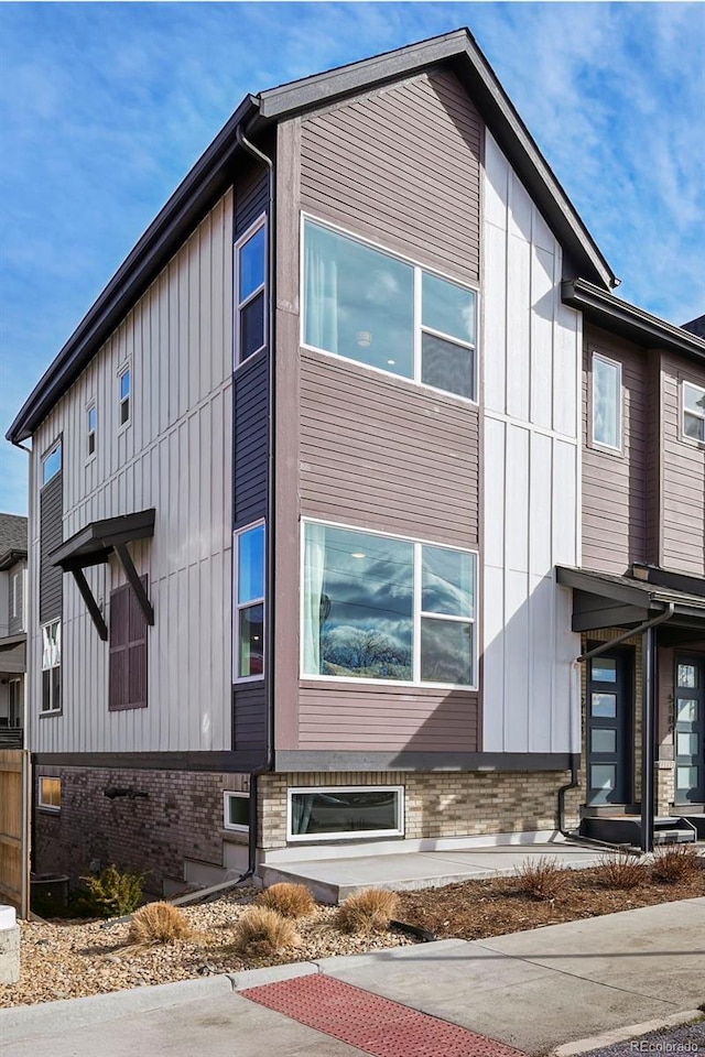 view of side of property with board and batten siding and brick siding