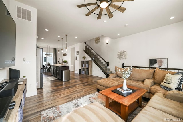 living area with visible vents, ceiling fan, stairway, dark wood-type flooring, and recessed lighting