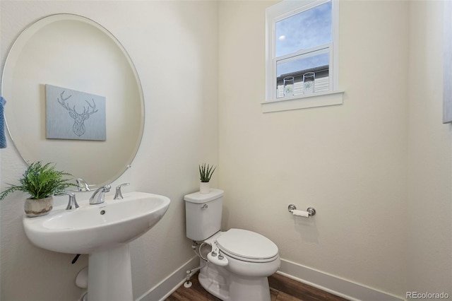 bathroom with wood finished floors, toilet, and baseboards