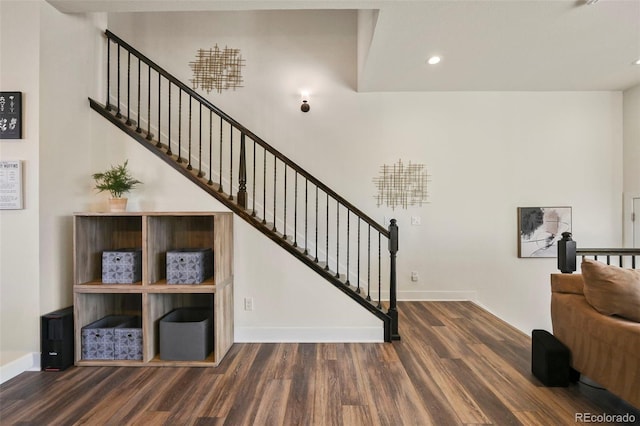 stairs featuring baseboards, wood finished floors, and recessed lighting