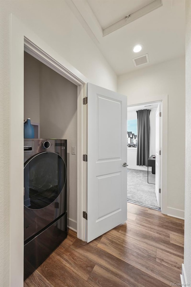 clothes washing area with washer / dryer, laundry area, baseboards, wood finished floors, and recessed lighting