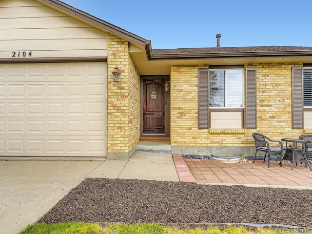 2104 Vineyard Dr, Castle Rock, CO 80104 - property entrance with brick siding, a garage, and driveway