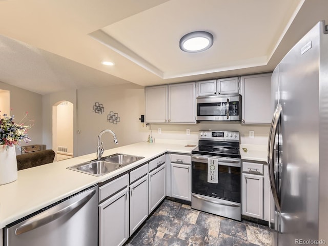 2104 Vineyard Dr, Castle Rock, CO 80104 - kitchen featuring appliances with stainless steel finishes, gray cabinets, light countertops, a peninsula, and a raised ceiling