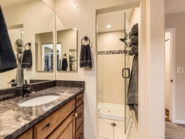 2104 Vineyard Dr, Castle Rock, CO 80104 - full bath featuring a shower stall, vanity, and a textured wall