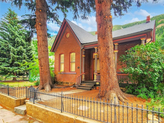 808 Rose St, Georgetown, CO 80444 - view of front of property with a shingled roof, brick siding, and a fenced front yard