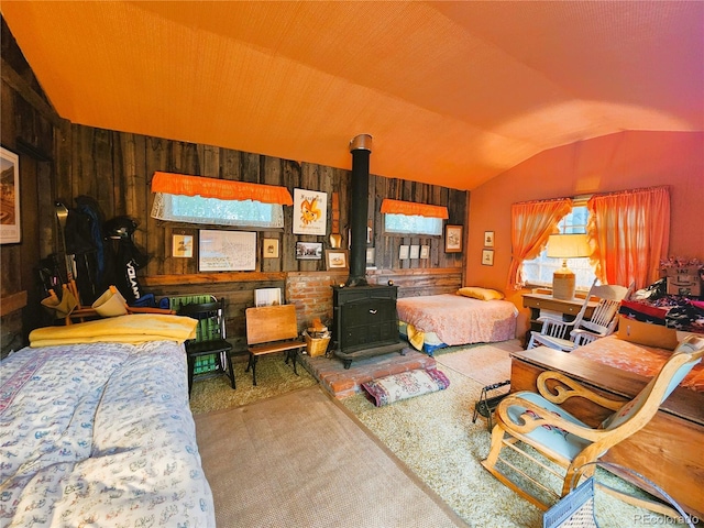 808 Rose St, Georgetown, CO 80444 - carpeted bedroom with vaulted ceiling, a wood stove, and wooden walls