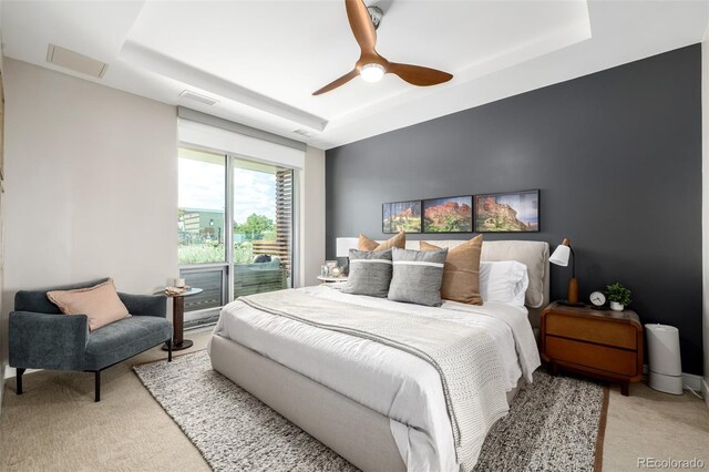 4200 W 17th Ave Unit 212, Denver, CO 80204 - bedroom featuring a tray ceiling, light colored carpet, and ceiling fan