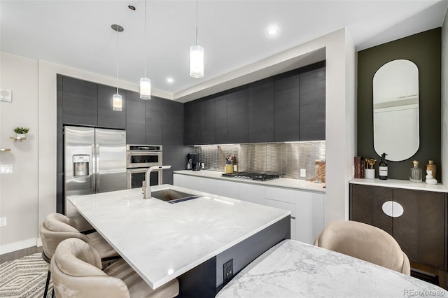 4200 W 17th Ave Unit 212, Denver, CO 80204 - kitchen featuring stainless steel appliances, modern cabinets, light countertops, a kitchen breakfast bar, and backsplash
