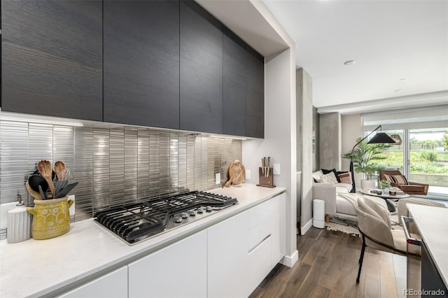 4200 W 17th Ave Unit 212, Denver, CO 80204 - kitchen with stainless steel gas stovetop, dark wood-style floors, decorative backsplash, light countertops, and modern cabinets