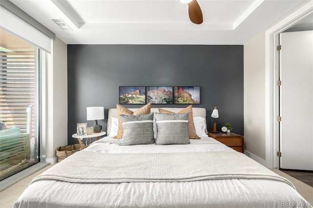 4200 W 17th Ave Unit 212, Denver, CO 80204 - carpeted bedroom featuring a raised ceiling, multiple windows, and ceiling fan