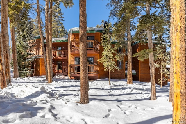 snow covered property with a balcony