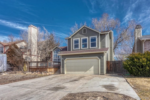 view of front of home with driveway, an attached garage, and fence