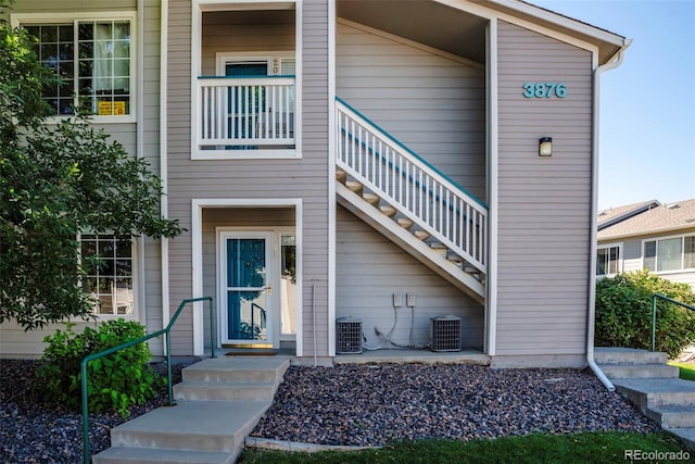 view of exterior entry featuring a balcony and central air condition unit