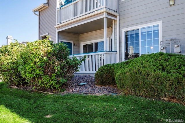 doorway to property featuring a balcony and a yard