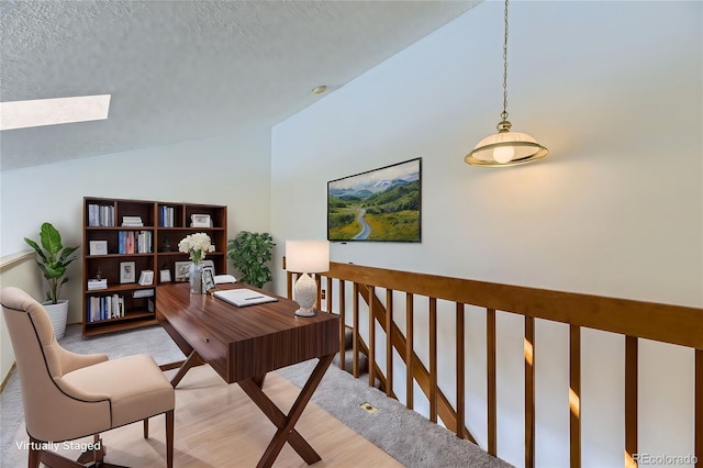 office space featuring a textured ceiling and vaulted ceiling with skylight