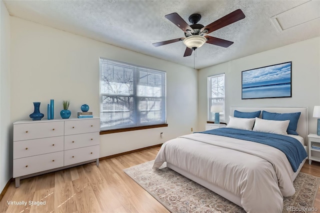 bedroom featuring a textured ceiling, ceiling fan, and light hardwood / wood-style flooring