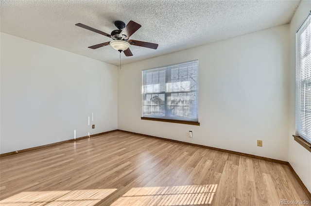 empty room with a textured ceiling, ceiling fan, light hardwood / wood-style floors, and a healthy amount of sunlight