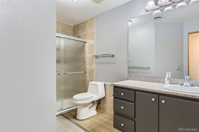 bathroom featuring toilet, an enclosed shower, and vanity