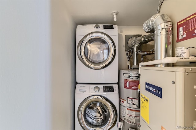 clothes washing area featuring water heater and stacked washer / drying machine