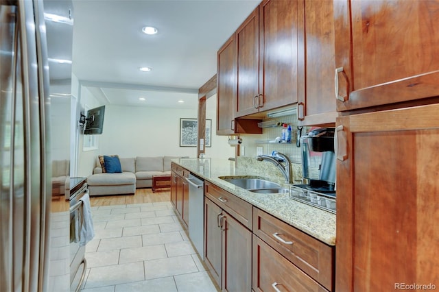 5690 E Cornell Ave, Denver, CO 80222 - kitchen featuring stainless steel appliances, light stone counters, light tile patterned floors, open floor plan, and recessed lighting