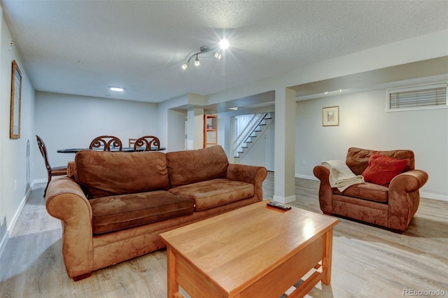 5690 E Cornell Ave, Denver, CO 80222 - living room featuring light wood-style flooring, a textured ceiling, and stairway