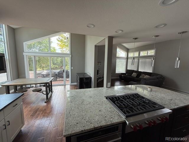 1545 W 148th Ave, Westminster, CO 80023 - kitchen featuring light stone countertops, open floor plan, range, pendant lighting, and dark wood finished floors