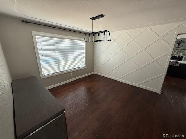 1545 W 148th Ave, Westminster, CO 80023 - unfurnished dining area featuring baseboards and dark wood-type flooring
