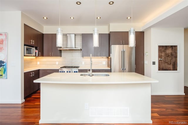 907 E 22nd Ave, Denver, CO 80205 - kitchen featuring stainless steel appliances, wall chimney exhaust hood, light countertops, dark wood finished floors, and recessed lighting