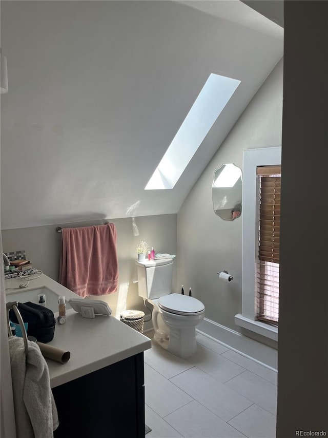 819 27th St, Denver, CO 80205 - half bathroom with a skylight, lofted ceiling, vanity, and tile patterned flooring