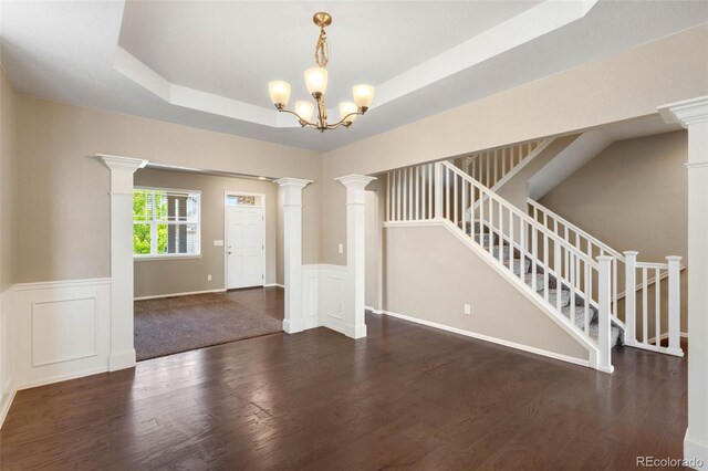 1339 Sidewinder Cir, Castle Rock, CO 80108 - spare room featuring wood finished floors, stairs, decorative columns, wainscoting, and a chandelier