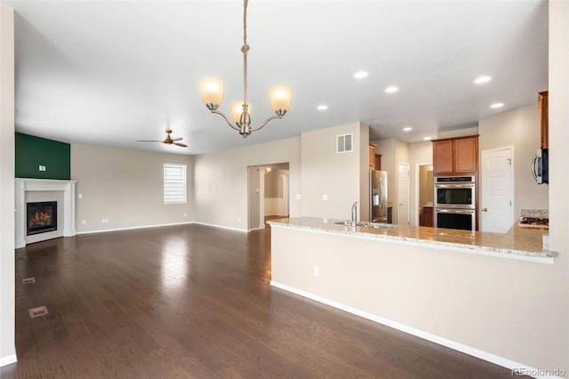 1339 Sidewinder Cir, Castle Rock, CO 80108 - kitchen featuring appliances with stainless steel finishes, ceiling fan, dark wood-style flooring, recessed lighting, and a tile fireplace
