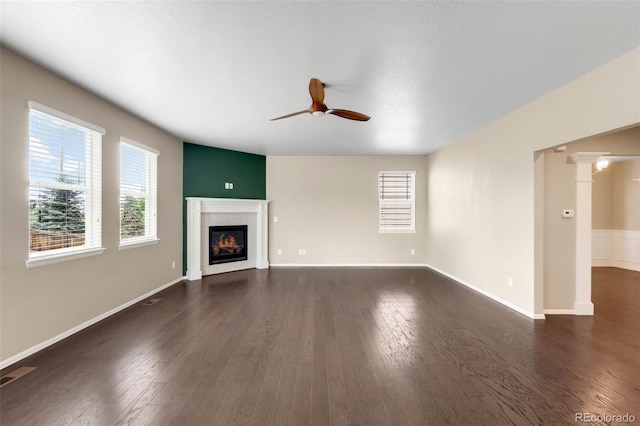1339 Sidewinder Cir, Castle Rock, CO 80108 - unfurnished living room featuring a ceiling fan, dark wood finished floors, ornate columns, and a fireplace