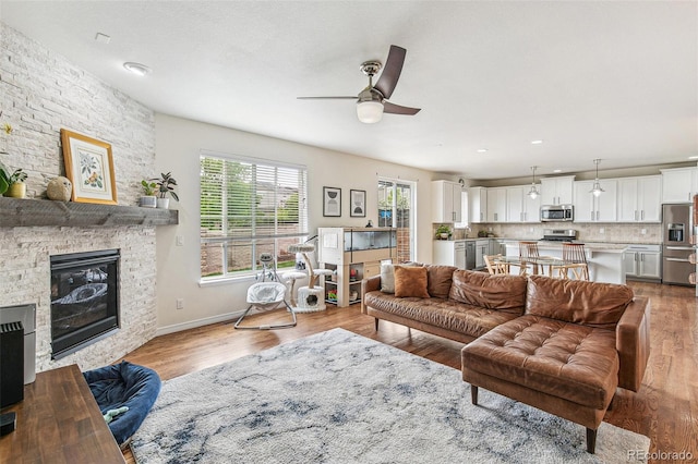 24356 E Powers Ave, Aurora, CO 80016 - living area featuring ceiling fan, wood finished floors, a fireplace, and baseboards