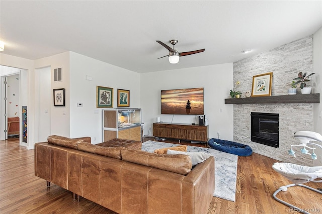 24356 E Powers Ave, Aurora, CO 80016 - living area with wood finished floors, a ceiling fan, and a stone fireplace