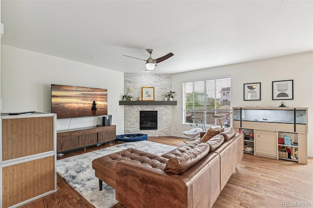 24356 E Powers Ave, Aurora, CO 80016 - living room with light wood-style floors, a fireplace, ceiling fan, and baseboards