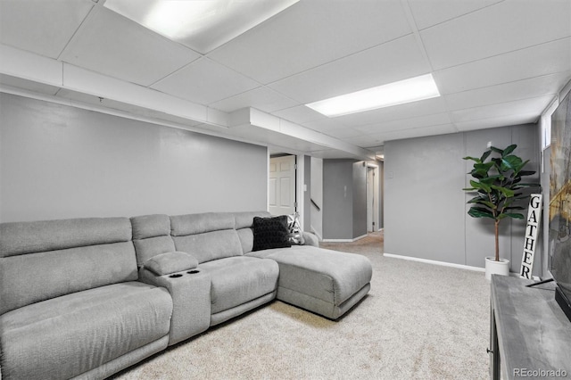 carpeted living room featuring a drop ceiling