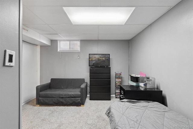 bedroom featuring light colored carpet and a drop ceiling