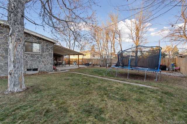 view of yard featuring a trampoline and a patio area