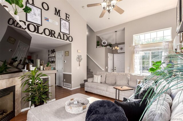 5972 S Zante Way, Aurora, CO 80015 - living room with high vaulted ceiling, stairs, ceiling fan, dark wood finished floors, and a tiled fireplace